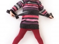 little girl in red tights and a bright dress on a white background